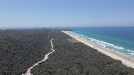 Rough-Road-Amidst-The-Forest-Of-North-Stradbroke-Island-And-Blue-Water-Of-The-Main-Beach-In-QLD,-Australia