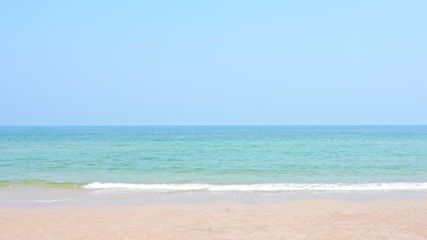 Leerer-Sandstrand-Und-Smaragdgrünes-Ruhiges-Meer-Schäumende-Gezeiten-Rollen-Auf-Sand-Auf-Unbewohnter-Insel-In-Thailand,-Wolkenloser-Himmel,-Urlaubsvorlage,-Kopierraum-Minimalistisch-Keine-Menschen