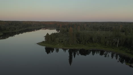 Flyover-at-sunset-above-lake-in-Boreal-Forest