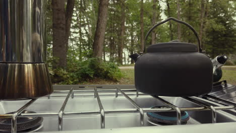 Camping-Kettle-With-Steam-On-A-Stove-With-Low-Fire-Outdoor