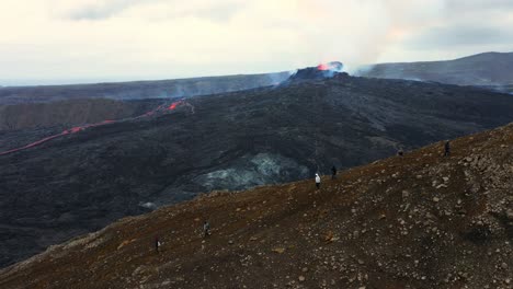 Erupción-Volcánica-Fagradalsfjall-En-Islandia-Con-Gente-Visitando-El-Volcán---Toma-Aérea-De-Drones