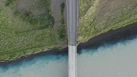 Two-rivers-blending-together-in-Iceland-with-bridge,-Confluence-phenomenon