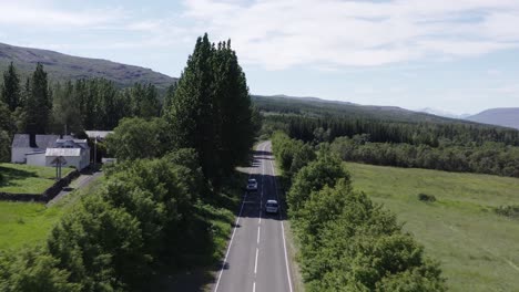 Coche-Viaja-En-Carretera-Rural-En-Islandia,-Vehículo-En-La-Calle-Que-Va-Al-Bosque-Hallormsstaður