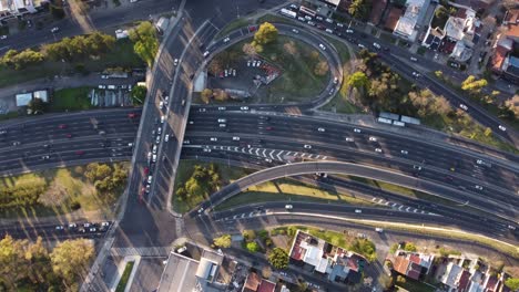 Cinematic-high-angle-top-down-of-busy-traffic-on-Pan-American-Highway,bridge-and-exits-during-sunset---Beautiful-texture-of-cars-in-motion---Aerial-orbit-shot