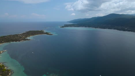 4K-Drone-clip-slowly-moving-backwards-over-a-tropical-island-in-the-bay-of-Vourvourou,-in-Chalkidiki,-northern-Greece