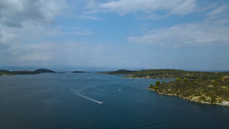Breathtaking-clip-from-a-drone-flying-forward-to-a-tropical-island-in-the-bay-of-Vourvourou,-in-Chalkidiki,-northern-Greece