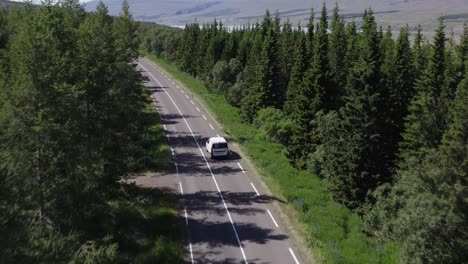Car-driving-through-beautiful-woodland-landscape-in-natural-Iceland,-aerial