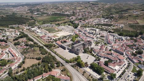 Aerial-scenic-view-of-Batalha-Monastery,-surrounding-town-and-IC2-motorway
