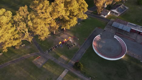 Aerial-top-down-of-kids-playing-at-playground-in-Sarmiento-Park-during-sunset-light---Buenos-Aires,South-America