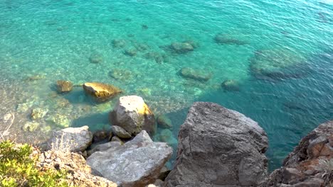 Calm-and-relaxing-slow-motion-view-of-clear-turquoise-sea-with-rocky-cliffs