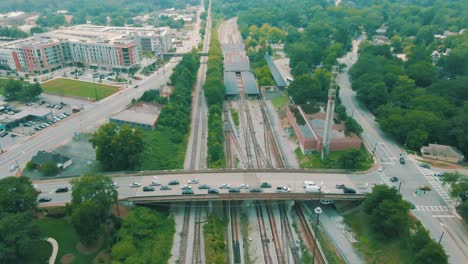 Drone-footage-of-a-train-station-and-car-traffic-going-over-a-bridge