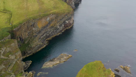 Downward-angle-drone-shot-of-Whaligoe-Haven-and-the-250ft-cliffs-overlooking-the-north-sea-in-Scotland