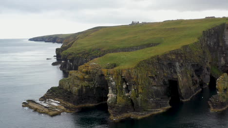Rotating-wide-drone-shot-of-Whaligoe-Haven-and-the-rocky-250ft-cliffs-overlooking-the-north-sea-in-Scotland