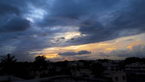 Dramatischer-Zeitraffer-Des-Sonnenuntergangs-über-Einer-Stadt-Mit-Wolken-Am-Himmel-Und-Orangefarbenen-Blautönen