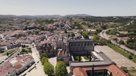 Batalha-city-rooftops-and-majestic-historical-monastery,-aerial-drone-orbit-view
