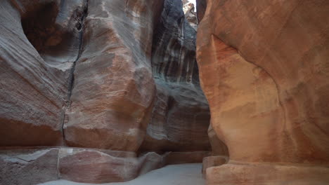 Narrow-Passage-Between-Steep-Cliffs,-Path-to-Petra-Temple,-Jordan,-Tilt-Down