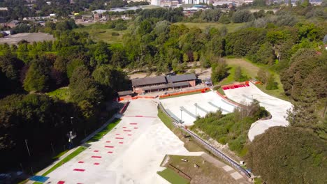 aerial-pan-shot-of-empty-dry-ski-slope-and-lift-in-norwich,-england
