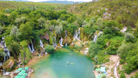 Locals-And-Tourists-Enjoying-Kravica-Waterfall-With-Green-Nature-Landscape-In-Bosnia-and-Herzegovina