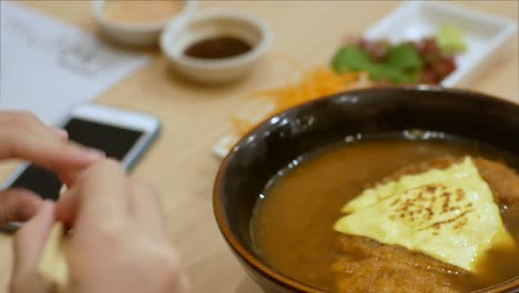 4k-video-to-the-bowl-of-curry-noodle-with-pork-cutlet-on-top-with-cheese-in-Japanese-food-style,-ready-to-eat-meal