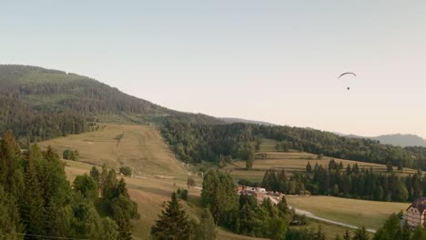 Luftdrohnenaufnahme-Eines-Gleitschirms-über-Einem-Wald-Und-Wiesen-In-Der-Niedrigen-Tatra-In-Der-Slowakei,-Mitteleuropa