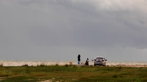 A-Family-Picnic-Along-the-Coast-with-Parked-Vehicle-Shot-with-Long-Focal-Distance-on-the-Grassy-Coastline