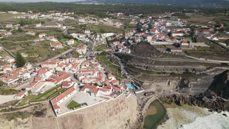 Aerial-pan-view-of-Azenhas-do-Mar-beautiful-town-on-top-of-oceanic-cliffs,-Portugal