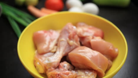 Raw-chicken-curry-cut-pieces-in-a-yellow-bowl-closeup,-leg-piece,-thighs