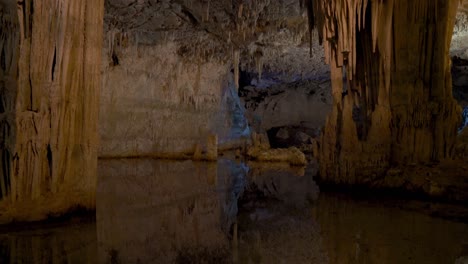 Water-reflection-at-huge-limestone-Neptune-Cave-with-stalagmites-and-stalactites-Tropfsteinhöhle-Grotta-di-Nettuno-in-Sardinia,-Italy