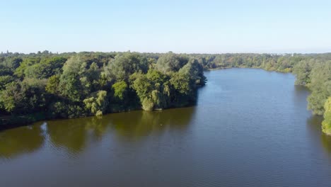 drone-shot-of-lake-and-forest-in-Norwich,-England