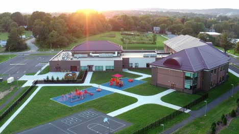 Aerial-of-school-building-in-USA-at-sunset,-sunrise