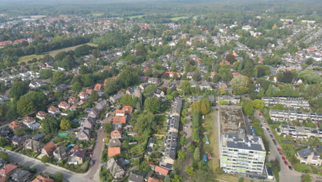 Wide-aerial-of-old-water-tower-standing-in-a-suburban-neighborhood