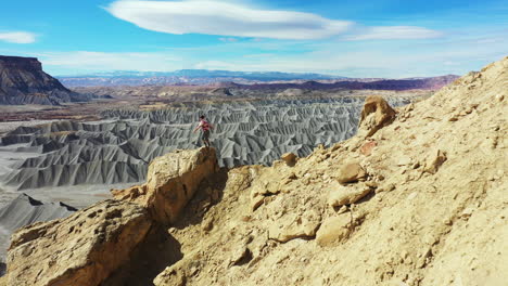 Man-Standing-on-Top-of-the-Rock-Above-Desert-Landscape-of-Utah