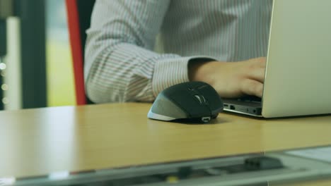 Kaukasischer-Mann,-Der-Am-Schreibtisch-Sitzt-Und-Remote-Arbeitet,-Benutzt-Laptop-Und-Maus
