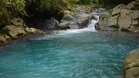 Fluss-Mit-Kristallklarem-Wasser,-Das-Zwischen-Felsen-Im-Regenwald-Von-Costa-Rica-Mit-Azurblauem-Wasser-Fließt
