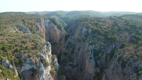 Rocky-canyon-reveal-shot-of-Palaiochora-Kythira-Castle,-Greece