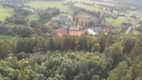 Stronie-Slaskie-Town-in-Poland,-Overhead-Aerial-Drone-Shot,-Green-Forests,-Sports-Facility,-Houses