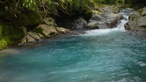 Blauer-Fluss-Mit-Kristallklarem-Wasser-Zwischen-Felsen-Im-Regenwald-Von-Costa-Rica-Mit-Azurblauem-Wasser