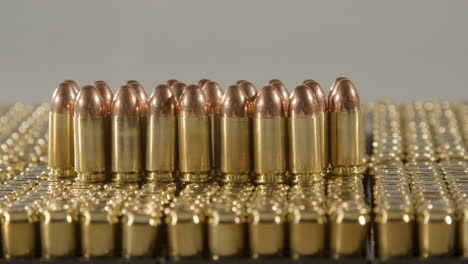 Dolly-of-bullets-standing-on-boxes-of-ammunition-against-a-white-background