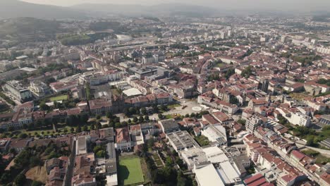 Aerial-circular-view-of-Braga-and-the-surrounding-mountains,-with-contrast-between-modern-architecture-and-beautiful-old-buildings