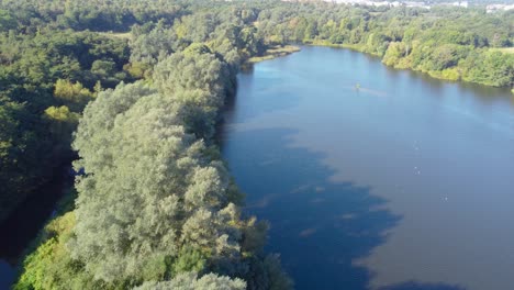 going-forward-drone-shot-of-lake-and-forest-in-Norwich,-England