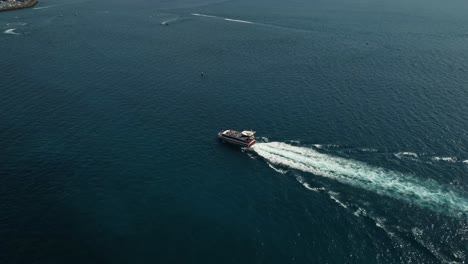 Barco-Navegando-En-Aguas-Abiertas-En-El-Mar-Junto-Al-Mar-Azul-Agua-Drone-Rodada-En-España-Tenerife-Los-Cristianos
