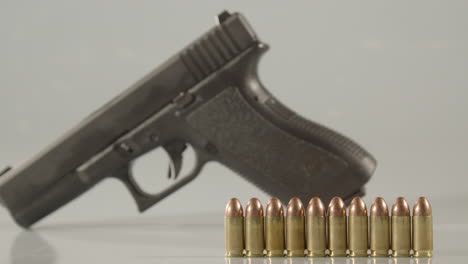 Dolly-of-9-millimeter-cartridges-with-a-handgun-in-the-background