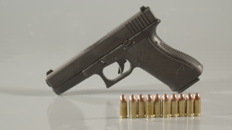 Dolly-out-from-9mm-handgun,-revealing-ammunition