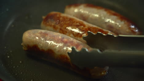 The-Chef-is-turning-delicious-sausages-while-searing-them-in-a-non-stick-pan