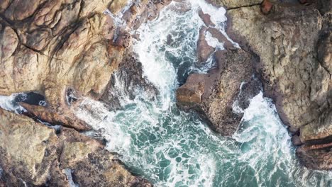 Aerial-cinematic-view-waves-crushing-rocks-top-view,-waves-and-ocean
