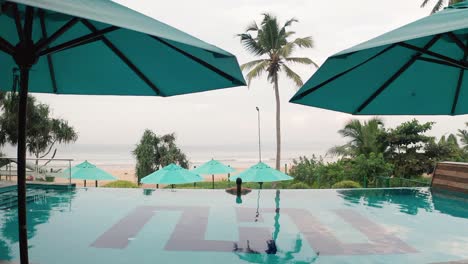 Frau-Im-Infinity-Pool-Genießt-Luxuriösen-Lebensstil-Im-Hotel-Spa-Mit-Blick-Auf-Einen-Strand