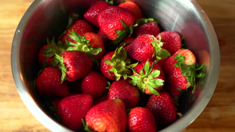 Close-up-shot-of-Freshly-picked-strawberries-are-being-placed-inside-a-metal-container