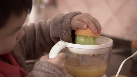 Slow-motion-close-up-footage-of-a-kid-learning-to-make-fresh-orange-juice