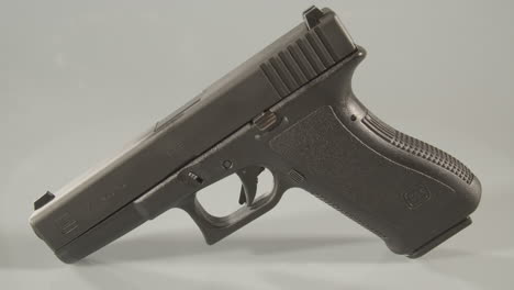 Panning-over-9mm-handgun-against-a-white-background