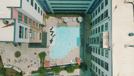 Unique-drone-footage-of-a-slow-push-into-the-pool-and-patio-area-of-an-apartment-complex